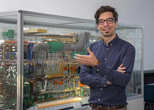 Florian Sprenger, der neue Leiter des Lehrstuhls für Schiffbau an der Universität Rostock vor dem Modell eines Schiffsmaschinenraums. Foto: Universität Rostock/Julia Tetzke