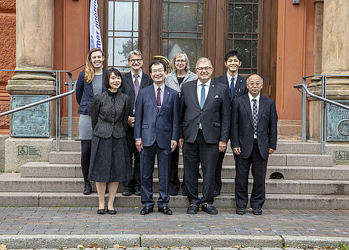 Delegation und Rektor vor dem Uni Hauptgebäude 