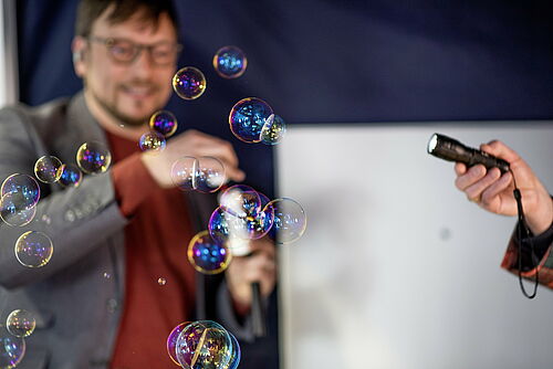 Prof. Dr. Boris Hage und die spektrale Aufspaltung von Licht an Seifenblasen. (Foto: Frank Hormann, nordlicht).