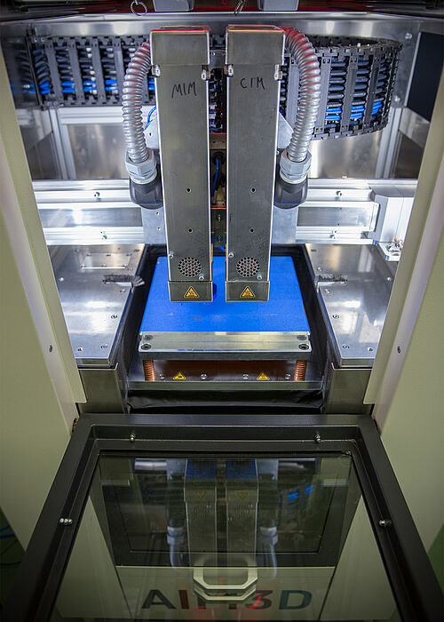  Bauraum des 3D-Druckers mit dem Herzstück der Maschine: zwei miniaturisierten Granulat-Extrudern