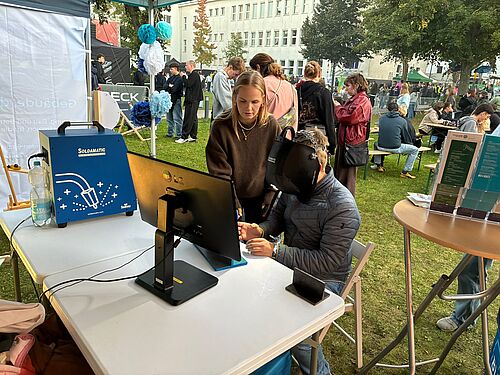 Die studentische Hilfskraft Maren Altenburg erläutert einem interessierten Festivalbesucher den Schweißsimulator. (Fotos: Reica Lindner).