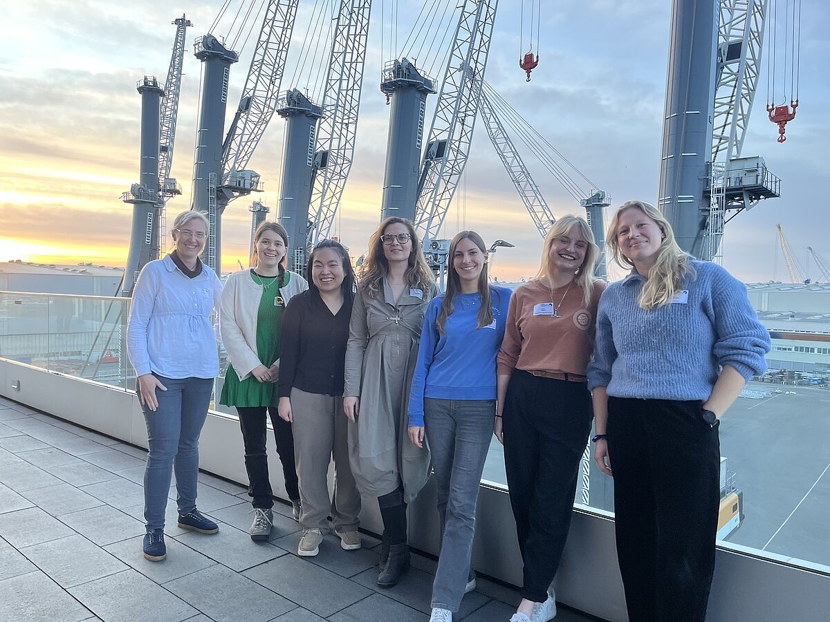 Frauen stehen draußen auf einer Terrasse bei einem Netzwerkevent.