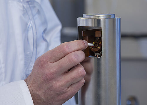 Ein Rotor, der die zu untersuchende Probe enthält, wird außerhalb des Magneten in den NMR-Probenkopf eingesetzt.