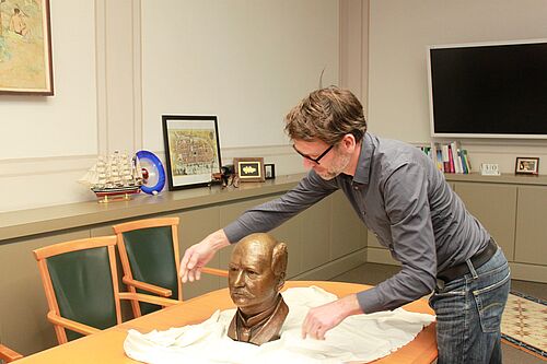 Rico Rensmeyer beim Entpacken der Büste von Albrecht Kossel. (Foto: Universität Rostock/Kristin Nölting).
