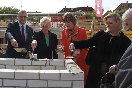 Grundsteinlegung für die neue geisteswissenschaftliche Bereichsbibliothek; v.l. Professor Karsten Wolf, Prorektor für Studium und Lehre, Simone Oldenburg, Ministerin für Bildung und Kindertagesförderung Mecklenburg-Vorpommern, Susanne Bowen, Staatssekretärin im Ministerium für Wissenschaft, Bundes- und Europaangelegenheiten Mecklenburg-Vorpommern Antje Theise, Direktorin der Universitätsbibliothek Rostock, und Stefan Wenzl, stellvertretender Staatssekretär im Ministerium für Finanzen und Digitalisierung Mecklenburg-Vorpommern. (Foto: Universität Rostock/Kristin Nölting).
