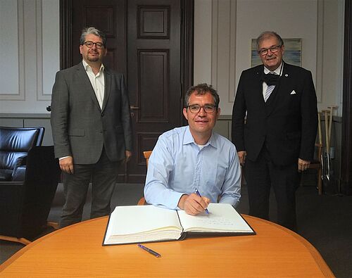 Bildunterschrift: (v.l.) Prof. Wolfgang Muno, Prof. Daniel Stockemer und Prof. Wolfgang Schareck, Rektor der Universität Rostock
