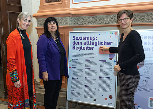 Professorin Elizabeth Prommer, Rektorin der Universität Rostock (Mitte), Professorin Nicole Wrage-Mönnig, Prorektorin für Forschung, Talententwicklung und Chancengleichheit, und Gleichstellungsbeauftragte Dr. Heidrun Jander eröffnen im Foyer des Universitätshauptgebäudes die Ausstellung „Gemeinsam gegen Sexismus“. (Foto: Universität Rostock/Julia Tetzke).