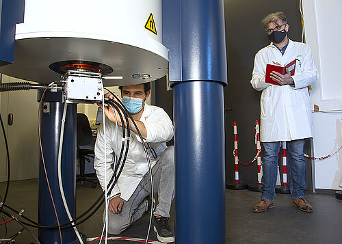 Masterstudent Eduard Mock stimmt den NMR-Probenkopf für das Experiment ab; Postdoktorand Dr. Siavash Saeidpour notiert dabei die Parameter im Laborjournal. (Fotos (4): Universität Rostock/Julia Tetzke).