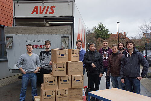 Karoly Dihen, Zoltán Kondor, Anton Ivanov, Peter Langer, David Kuhrt, Axel Block, Stefan Oschatz, Maksym Cherevatenko (v.l.) beim Beladen des LKW. (Foto: Universität Rostock/Institut für Chemie). 