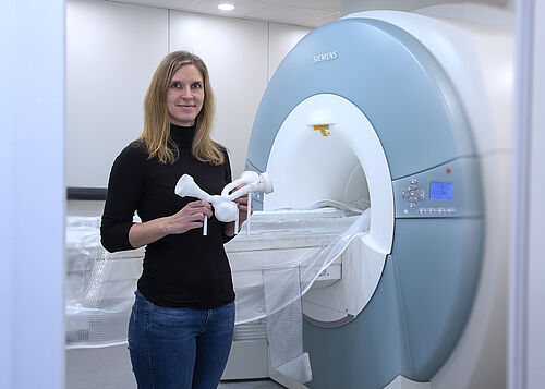 Carolin Wüstenhagen mit dem Aneurysmamodell vor dem Magnetresonanztomographen am Lehrstuhl für Strömungsmechanik. (Foto: Universität Rostock/Julia Tetzke).